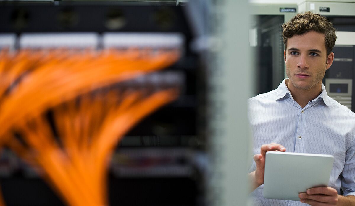 Man at server with orange hbus cable