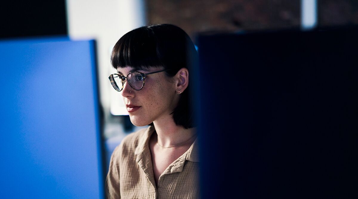 concentrating cybersecurity employee looking at computer screens