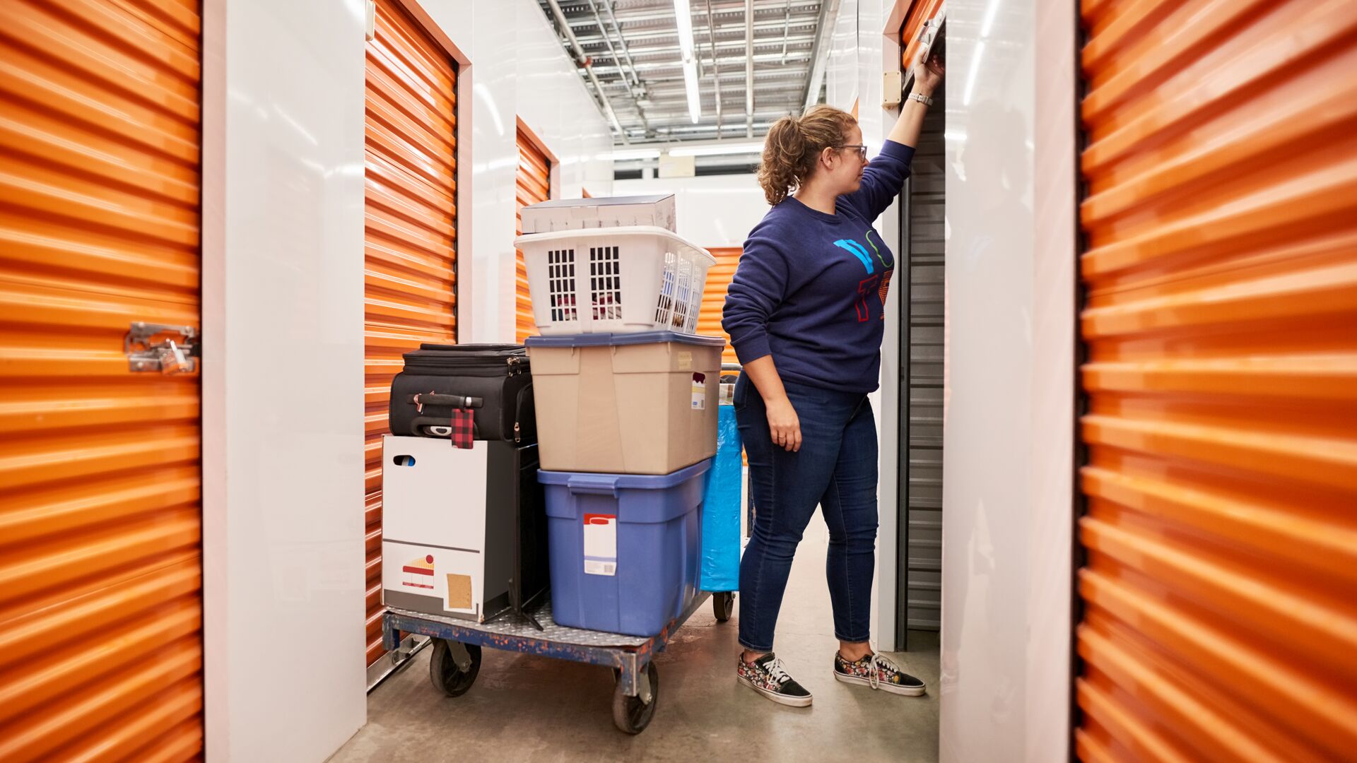 Protecting your self storage facility from the inside out blog hero image-General Purpose Woman closing door of self storage unit