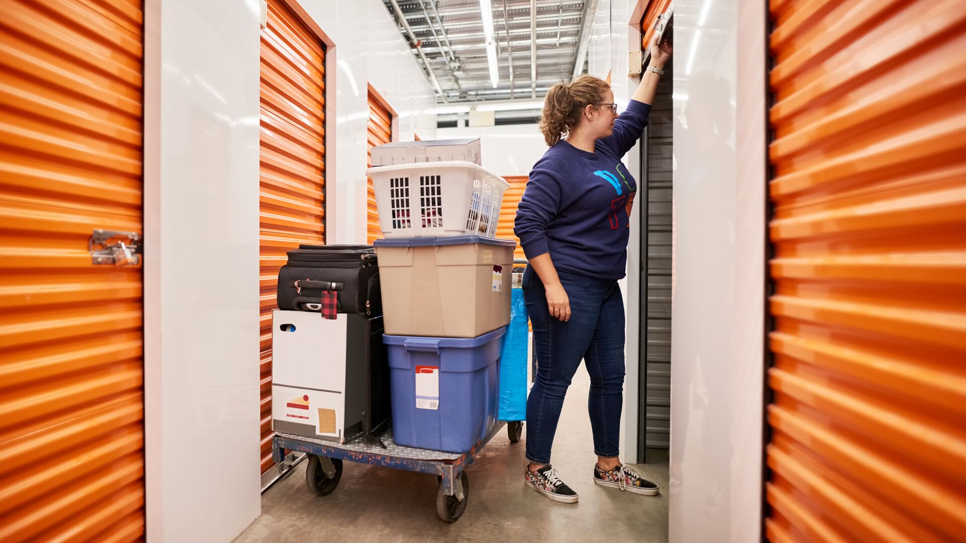 Woman closing door of self storage unit