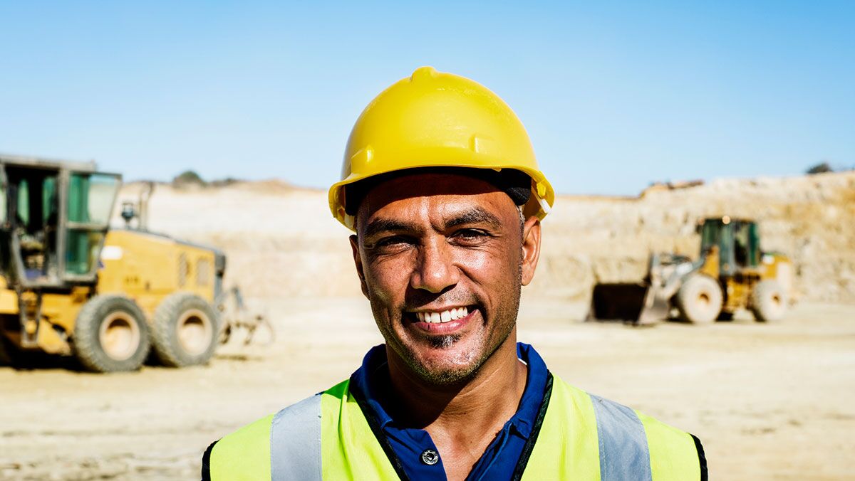 Revolutionizing Mining Operations Blog Hero Image-General Purpose smiling mine worker at mine site