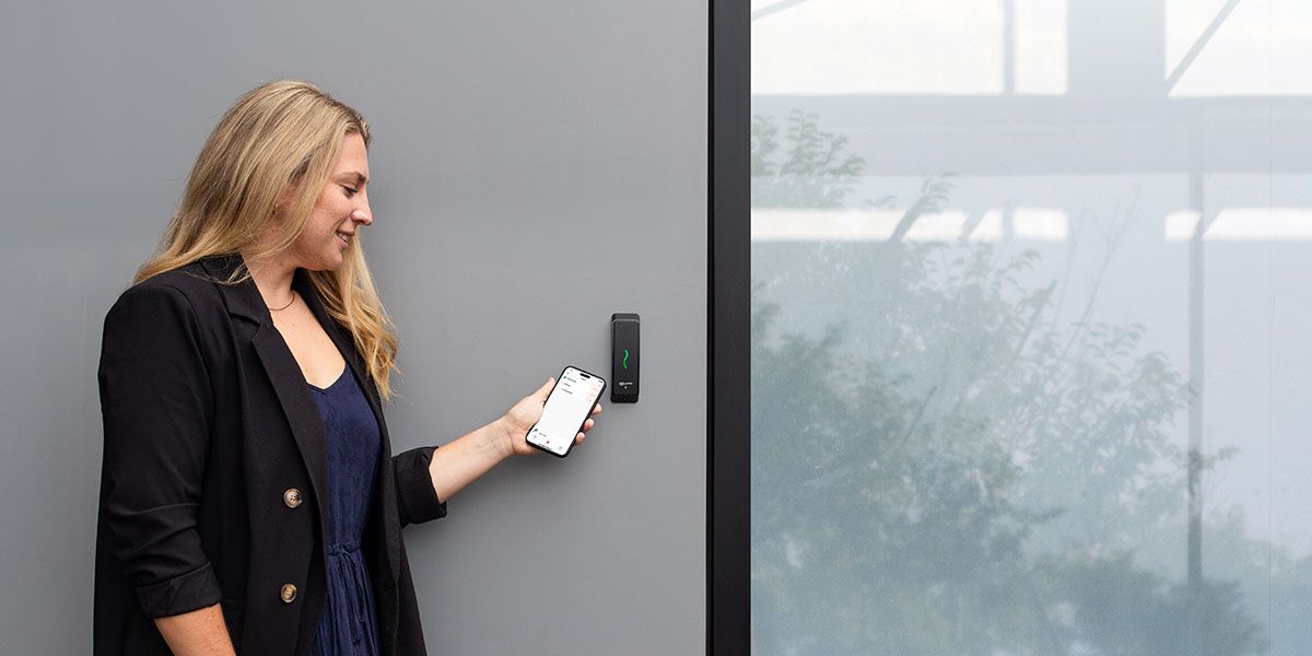 Employee badging their mobile credential at a physical security reader