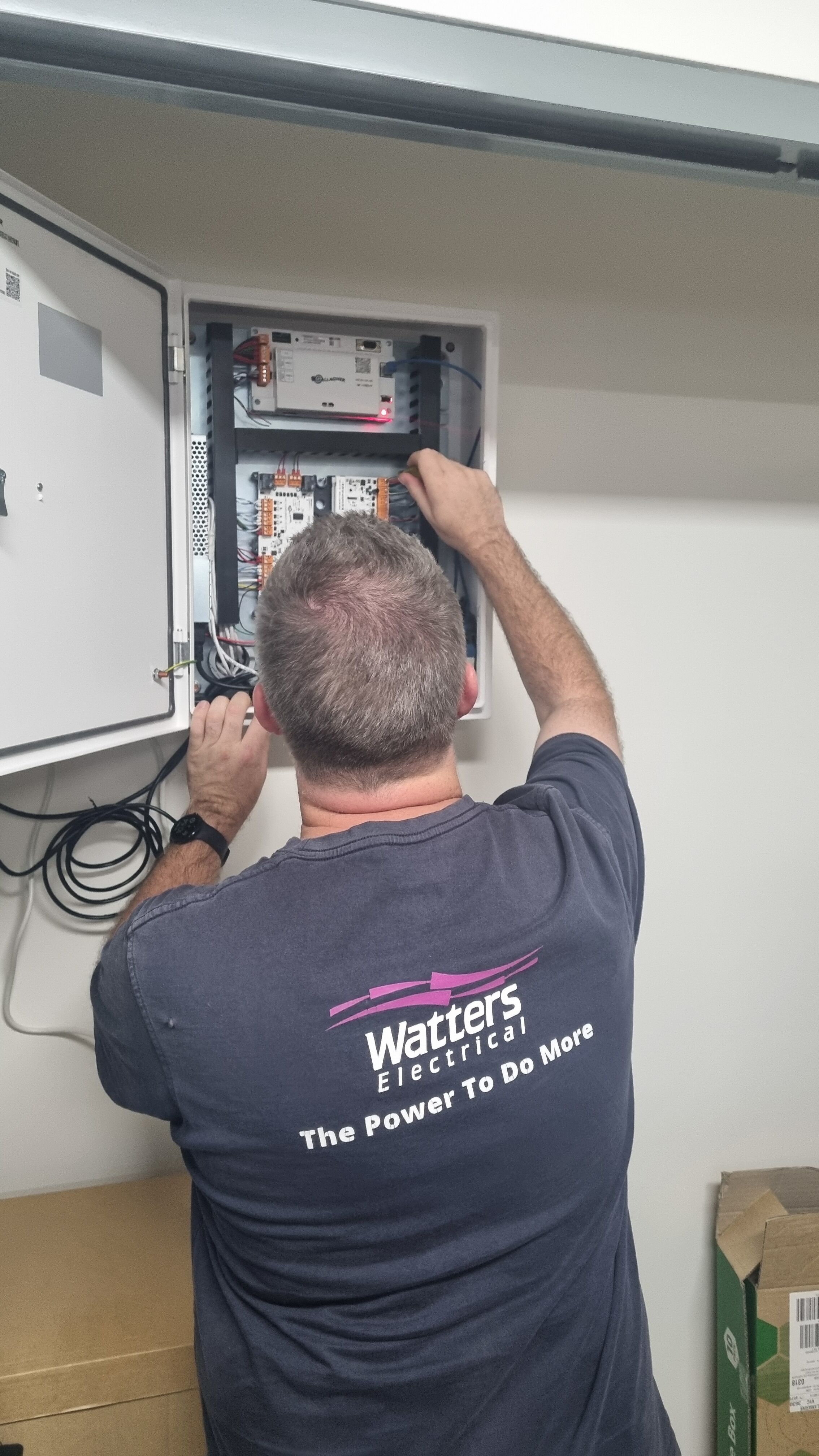 Watters Electrical employee installing Gallagher SMB kit in an office