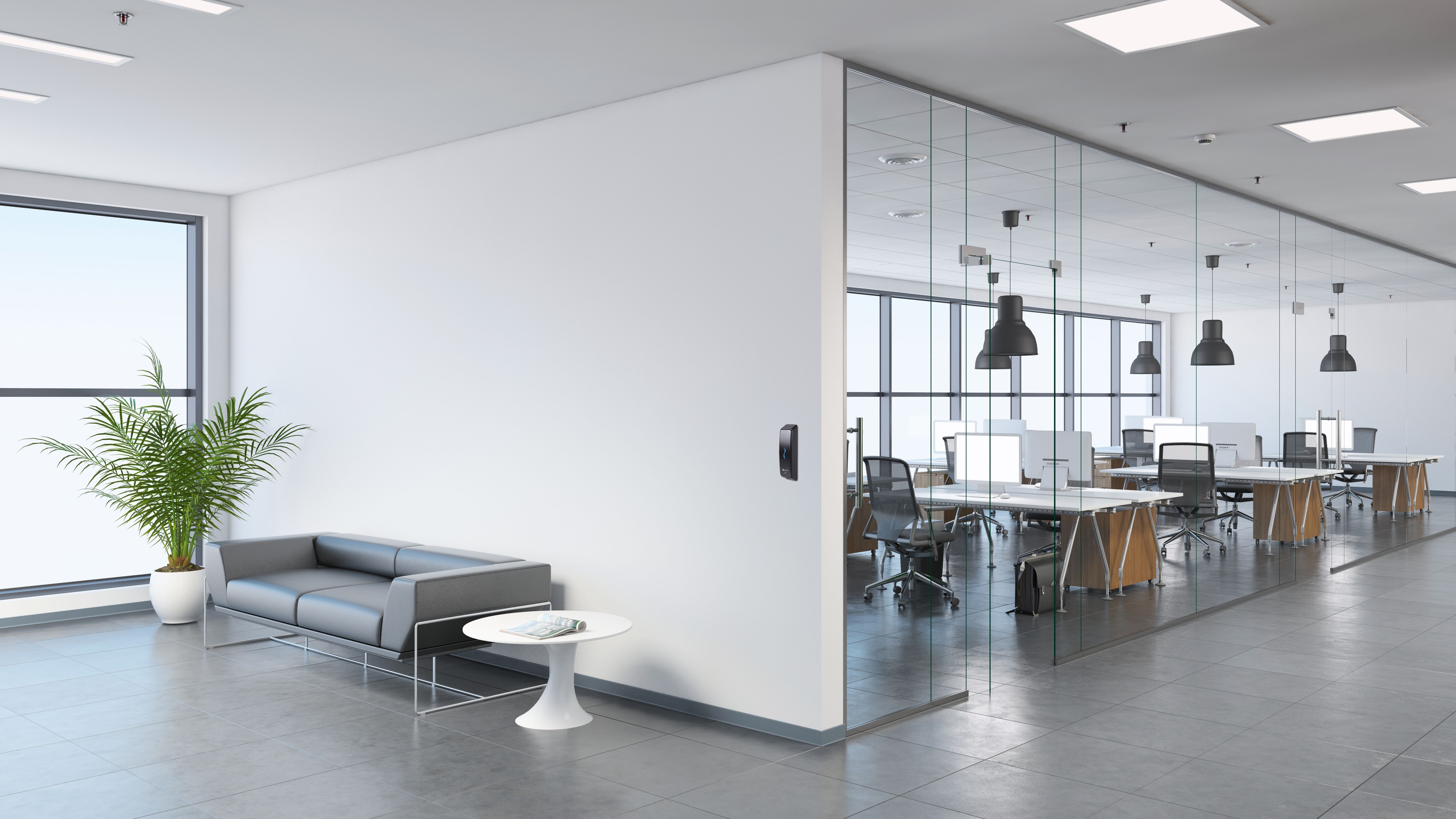 Shared Space with T15 (2)-General Purpose Interior view of a modern office, business template. Left side of the picture is large sofa with a plant and coffee table. Blank wall for copy space. On the right, many office desks with pendant lights above. large windows. gray floor tiles, white walls. Render