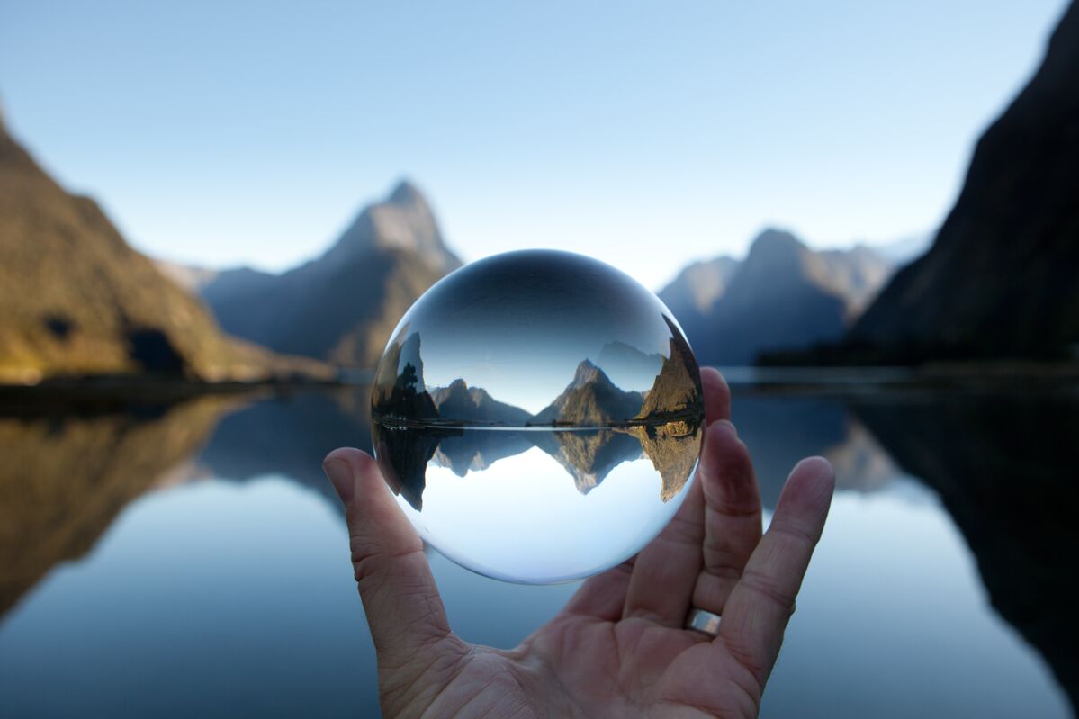 Man holding crystal ball in landscape photo