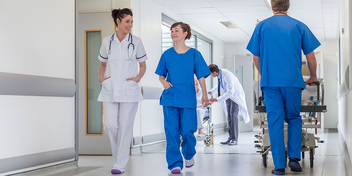 Nurse and doctor walking through hospital corridor
