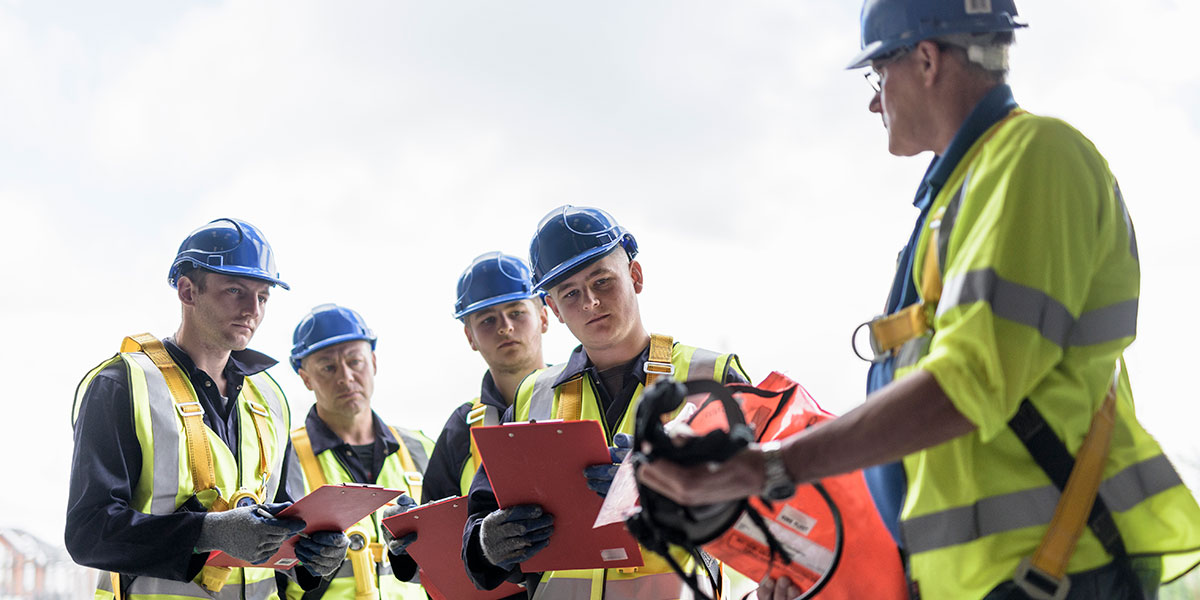 Foreman showing factory workers PPE