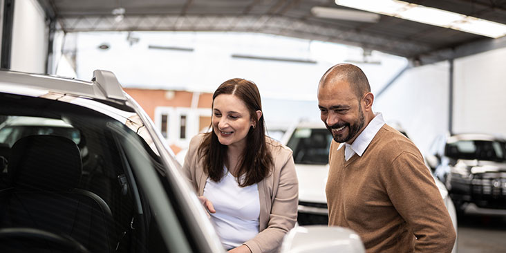 Salesman and customer shopping for new car in a car dealership