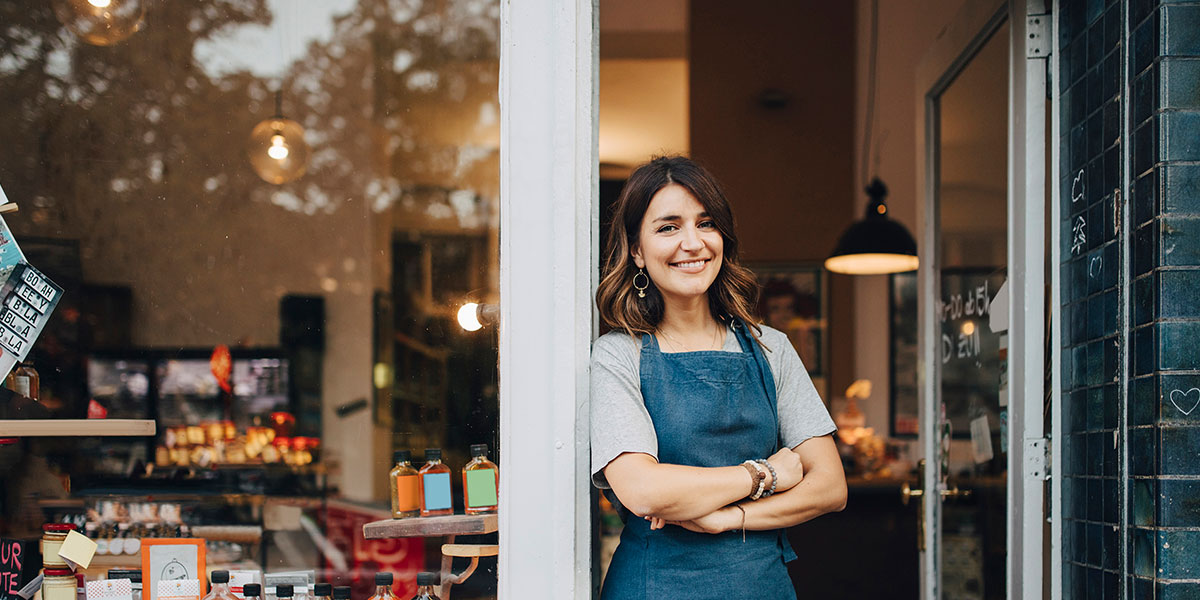small business owner stands in door of retail shop