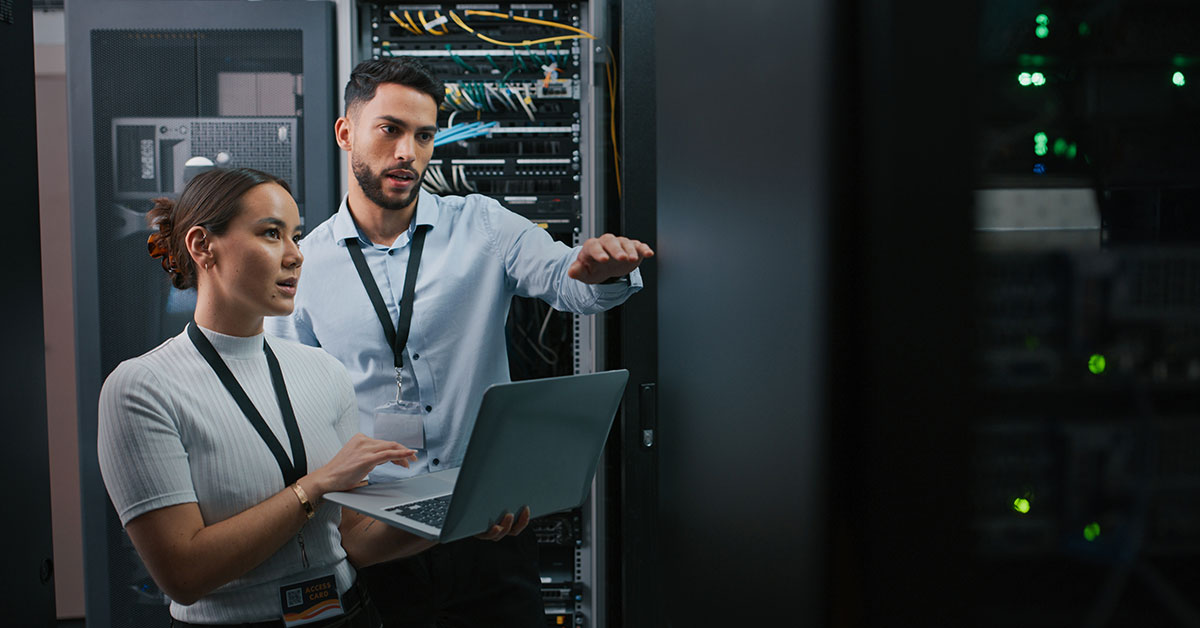 Two people looking at a server rack in data center server room