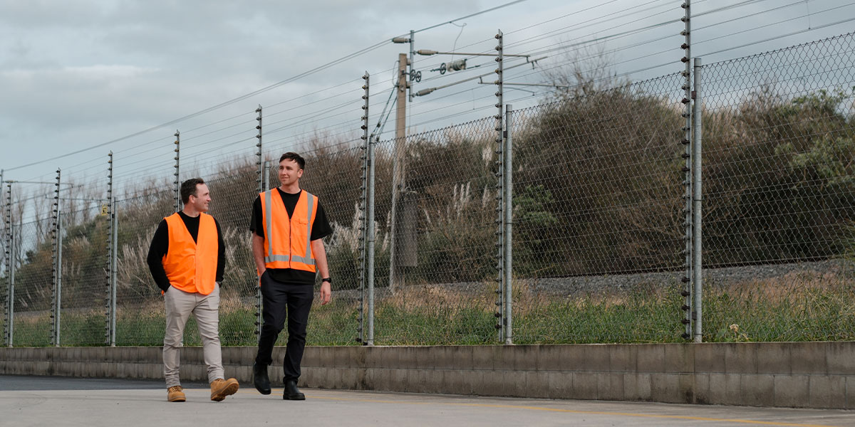 Contractors walking perimeter fence line