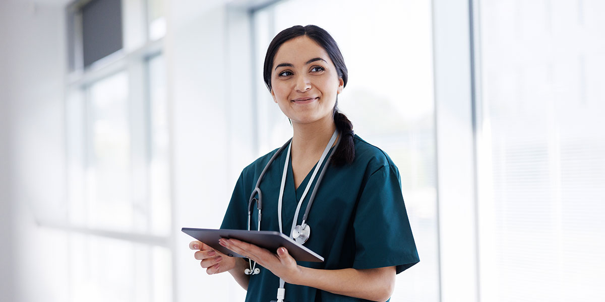 Young doctor smiling and looking down hospital corridor