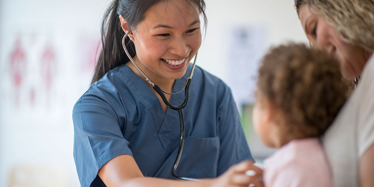Doctor listening to young patients heart with stethoscope