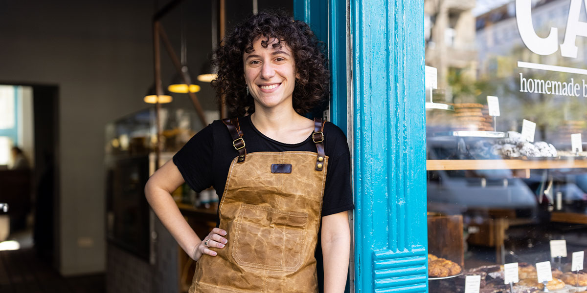 Portrait of small business owner standing in front of their bakery
