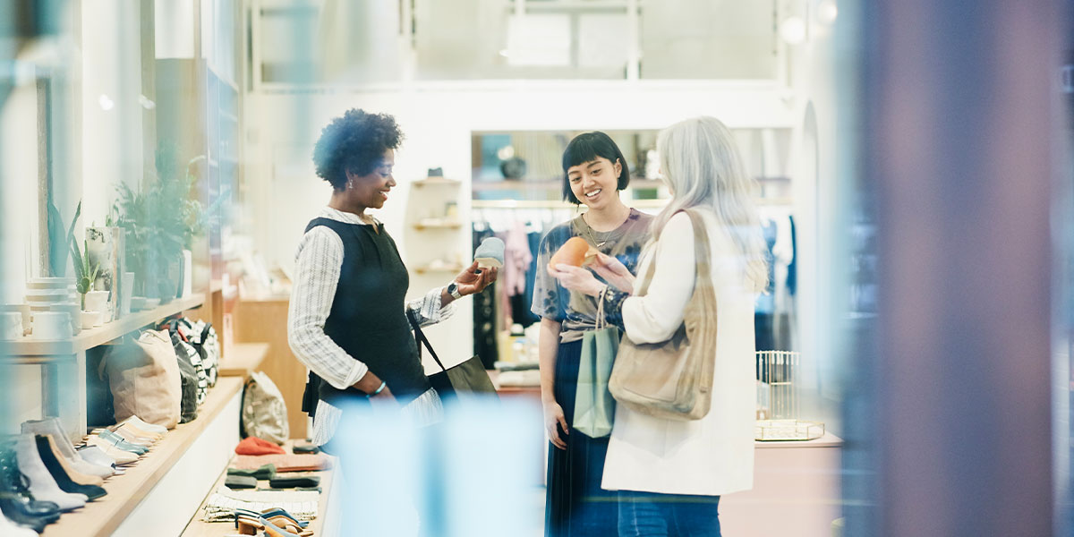 Three people looking at goods in a retail store