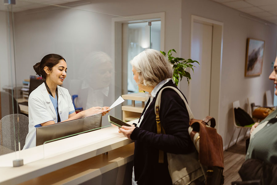 Smiling receptionist explaining visitor management procedure to visitor