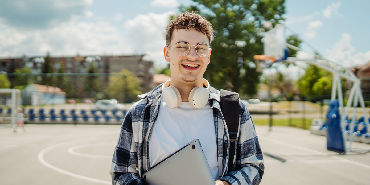 K-12 student standing in front of sports court