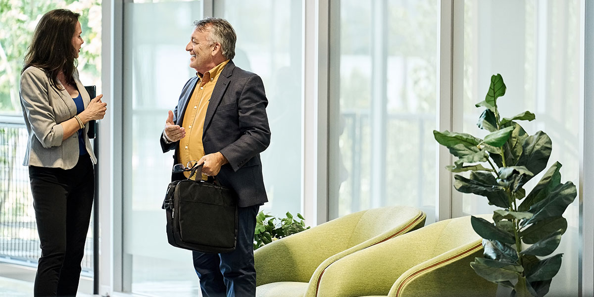 Business person welcoming visitor into office lobby