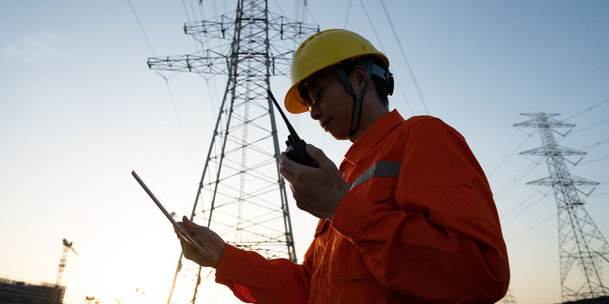 Technician in high vis inspecting powerlines