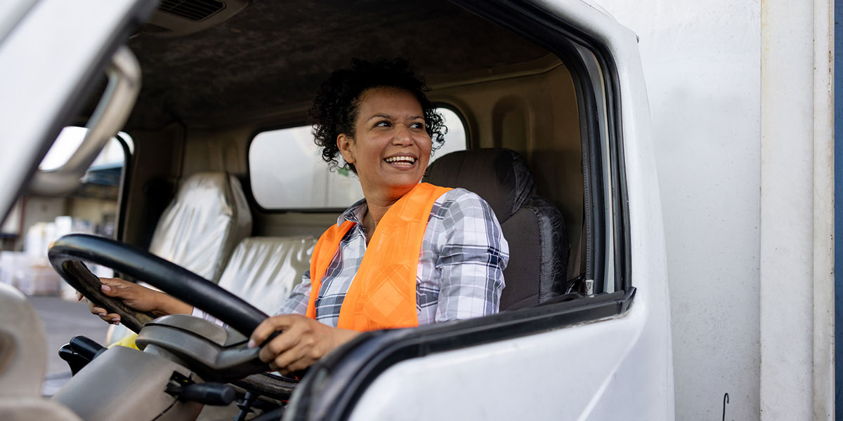 Female truck driver smiling while driving