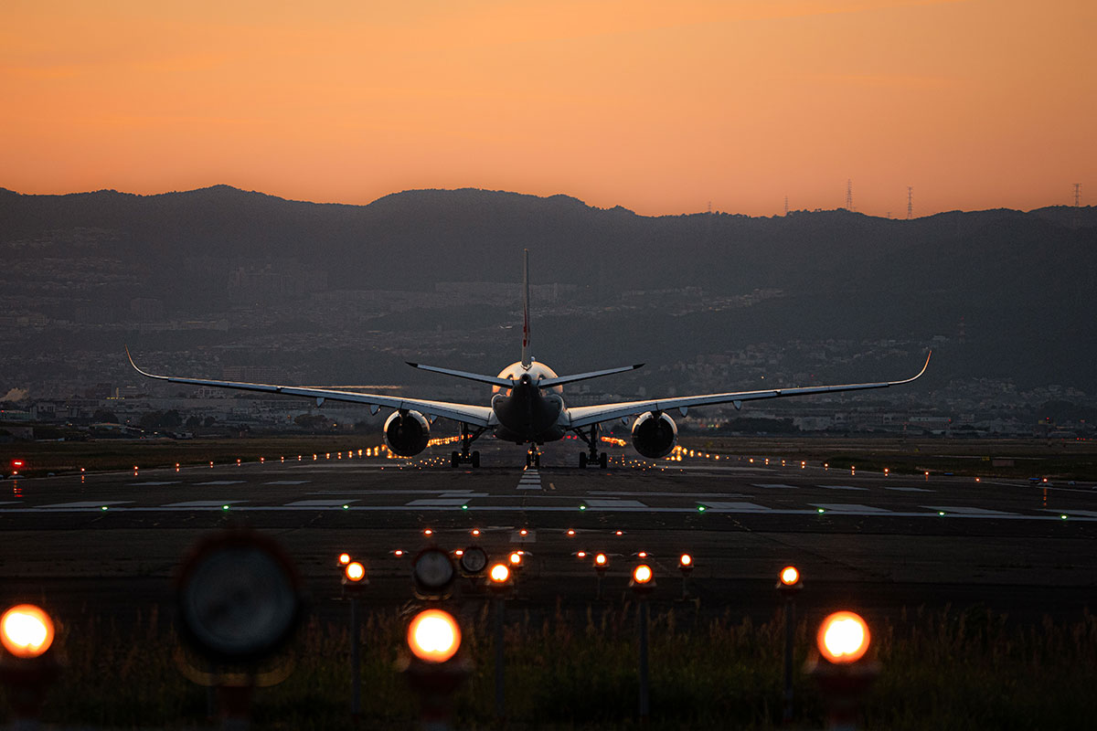 Plane landing on runway at sunset