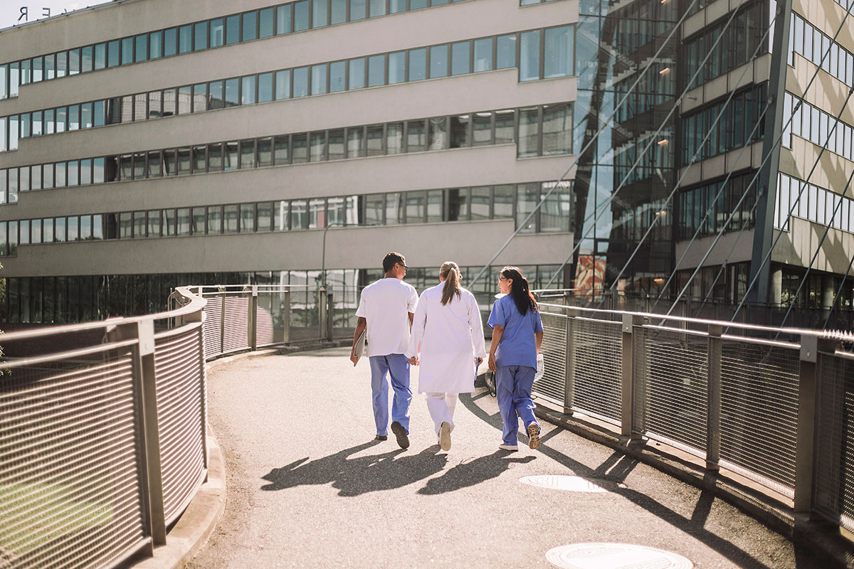 Doctor and nurse walking toward hospital building