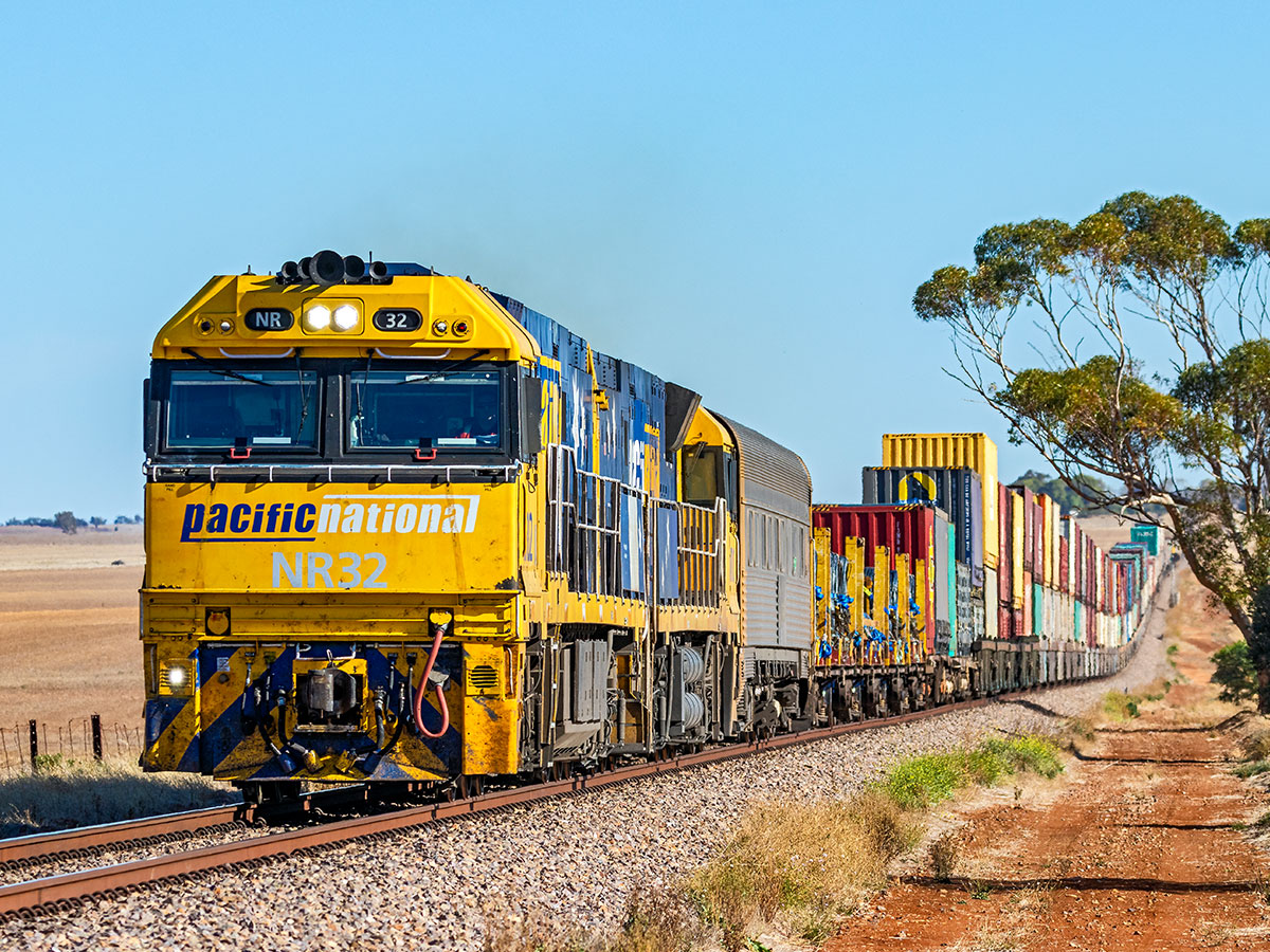 Pacific National interstate freight train with double stack containers in Australian outback