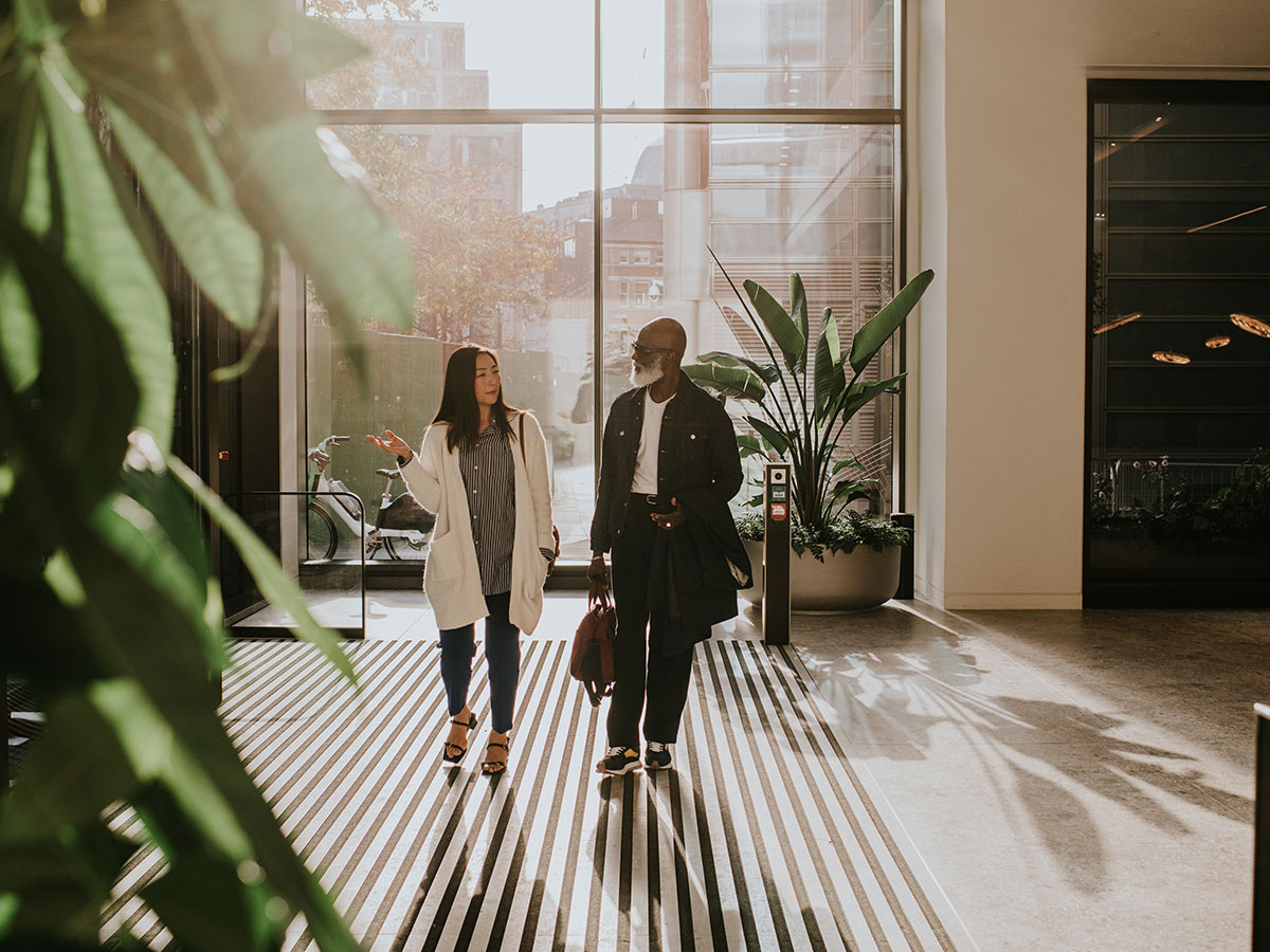 Two employees walking into commercial building lobby