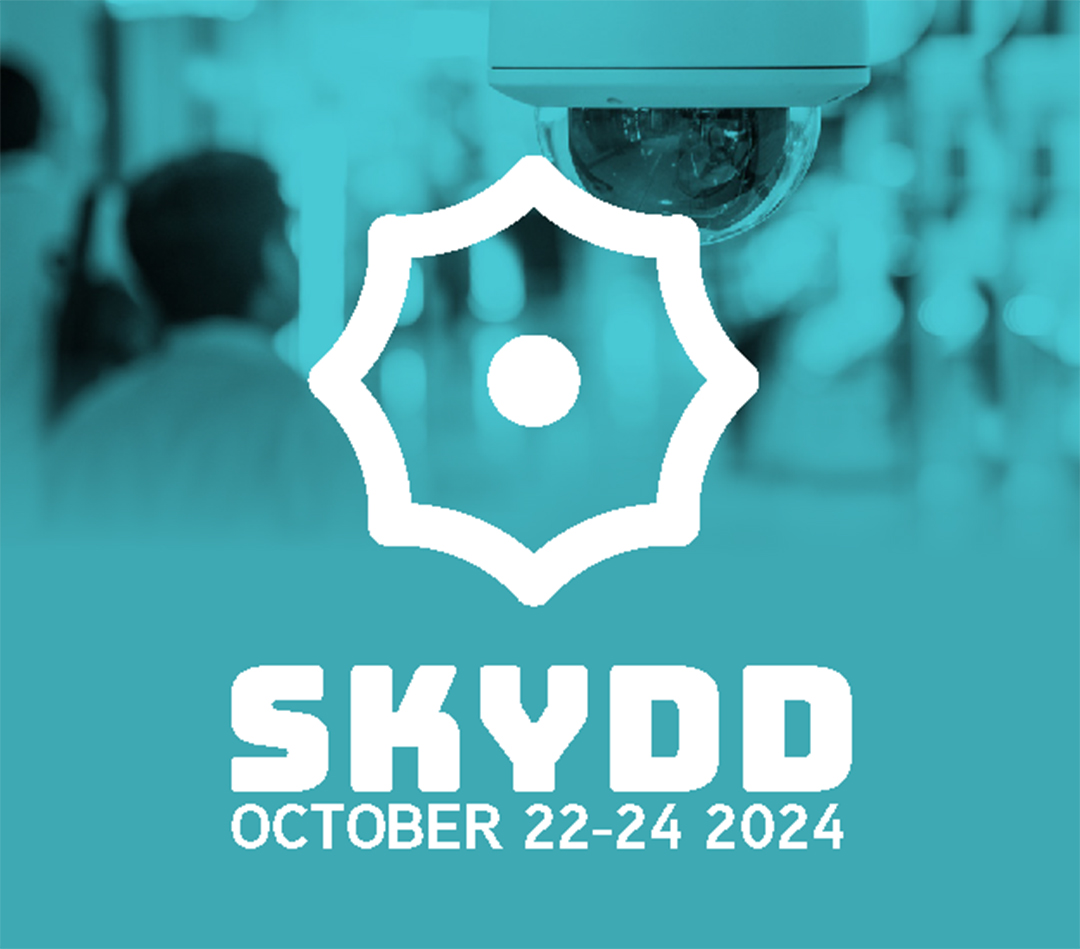 Skydd logo in front of a video camera and security professional